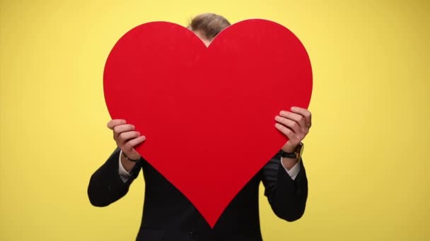 Jovem Empresário Infeliz Cobrindo Rosto Com Grande Coração Vermelho Revelando — Vídeo de Stock