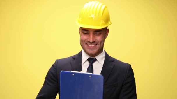 Jovem Engenheiro Feliz Usando Capacete Segurança Segurando Prancheta Apresentando Sorrindo — Vídeo de Stock