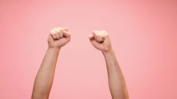空中で拳を握りピンクを背景に踊り勝利を祝う男 — ストック動画