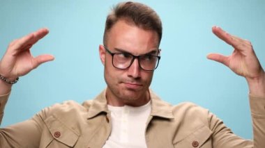 Sıradan bir adam mavi arka planda konuşan, tartışan ve gevezelik eden iki eliyle taklit yapıyor.