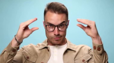 Tartışan ve gevezelik eden iki eli taklit eden sıradan bir adam ve mavi arka planda çok sinir bozucu.