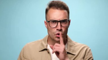 Yakışıklı, sıradan bir adam rahatsız oluyor ve sessizlik istiyor. Mavi arka planda 