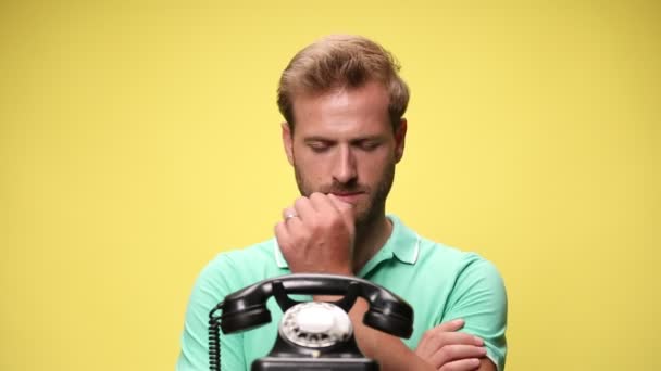 Glücklicher Junger Mann Der Auf Das Alte Telefon Schaut Wartet — Stockvideo