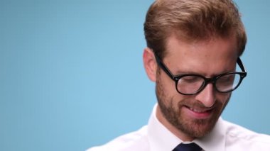 Genç bir iş adamının telefonu cevaplaması, konuşması, gülmesi ve mavi arkaplana kapatması.