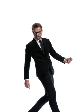 Beyaz arka planda gözlük takan, poz veren, el kol hareketi yapan ve yürüyen seksi genç iş adamı.