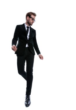 Siyah takım elbiseli havalı dramatik bir adam el ele tutuşup beyaz arka planda tek başına yürüyor.