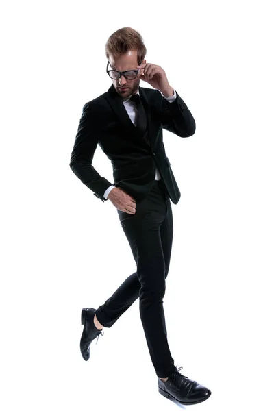 Moda Człowiek Czarny Garnitur Patrząc Dół Mocowania Okulary Trzymając Się — Zdjęcie stockowe