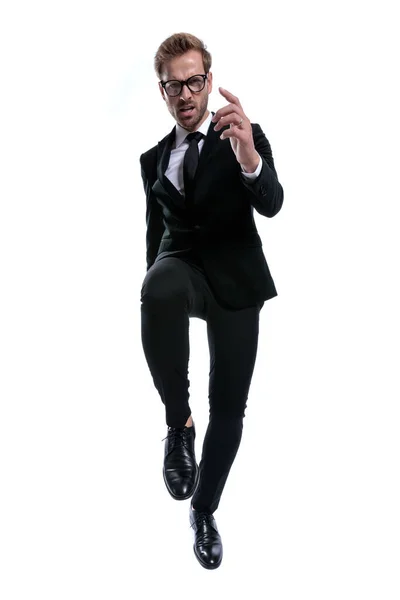 Cool Uomo Elegante Tuta Nera Tenendo Ginocchio Facendo Gesto Della — Foto Stock