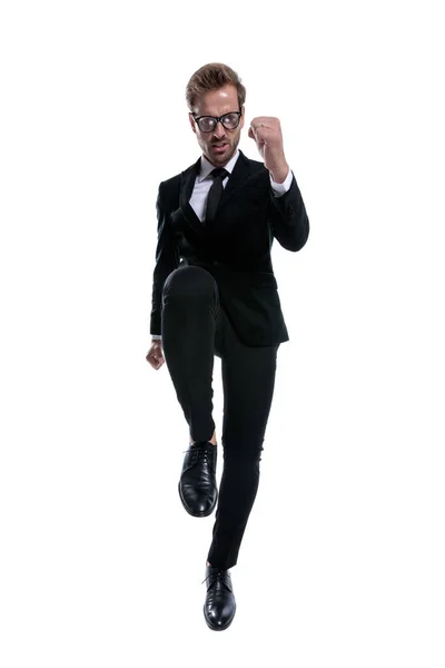 Dramatic Cool Man Black Suit Holding Leg Frowning Marching Isolated — Stock Photo, Image