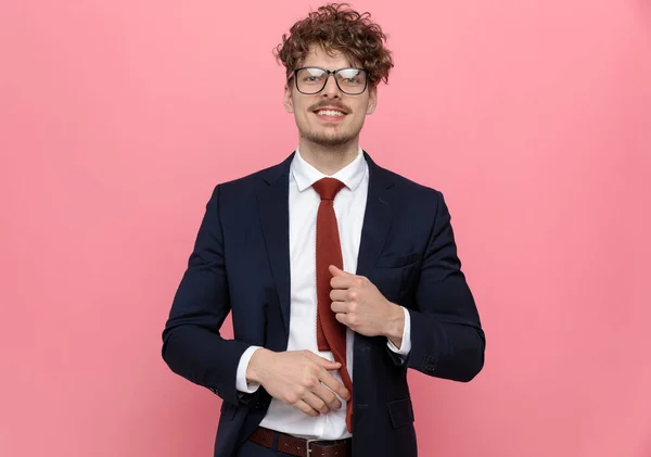 Elegancki Młody Biznesmen Granatowym Garniturze Noszący Okulary Regulujący Czerwony Krawat — Zdjęcie stockowe