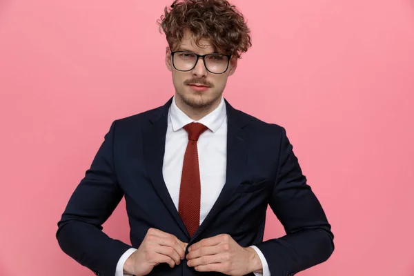 Sensual Young Businessman Wearing Glasses Buttoning Navy Blue Suit Fixing — Stock Photo, Image