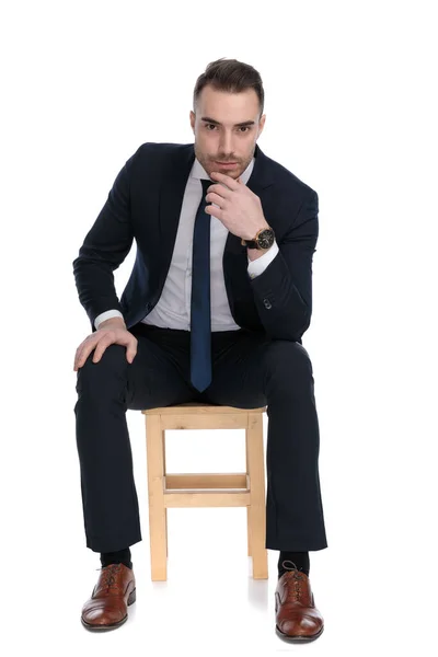 Důvěryhodný Podnikatel Drží Ruku Bradě Těší Zatímco Sedí Židli Bílém — Stock fotografie