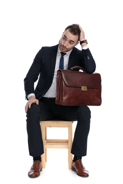 Pozorný Obchodník Drží Aktovku Ruku Hlavě Přemýšlí Zatímco Sedí Židli — Stock fotografie