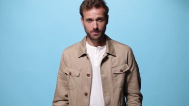 Çekici, sıradan bir adam aşağı bakıyor, sonra yukarı bakıyor, gülümsüyor ve iki eli de mavi arka planda başparmağını kaldırıyor.