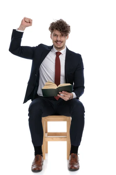 Bonito Empresário Segurando Seu Livro Seu Colo Celebrando Sucessos Fundo — Fotografia de Stock