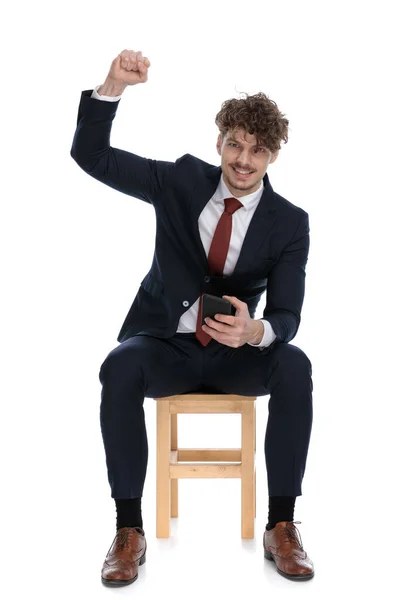 Guapo Empresario Emocionado Celebrando Éxitos Sosteniendo Teléfono Sentado Sonriendo Sobre — Foto de Stock