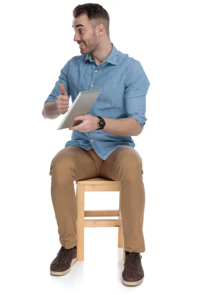 Šťastný Chytrý Ležérní Muž Drží Tablet Gestikuluje Při Posezení Židli — Stock fotografie