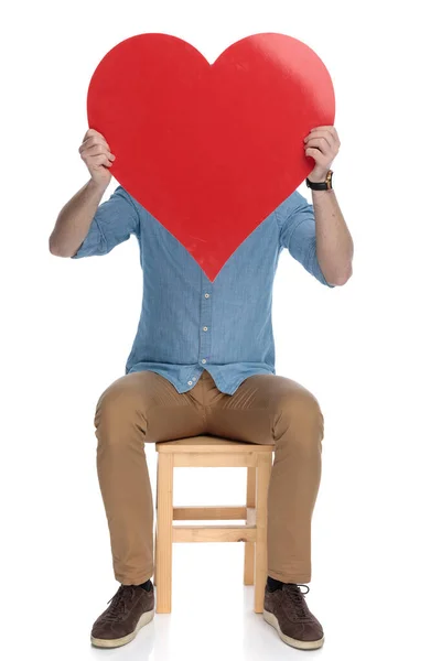 Beyaz Stüdyo Arka Planında Bir Sandalyede Otururken Yüzünü Kalp Şeklinde — Stok fotoğraf