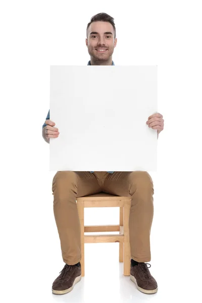 Pozitivní Chytrý Ležérní Muž Drží Prázdný Billboard Usmívá Zatímco Sedí — Stock fotografie