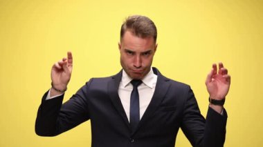 Önce konuşan bir elle taklit yapan işadamı, sonra diğer eliyle, sonra sarı arka planda tartışan iki eliyle.