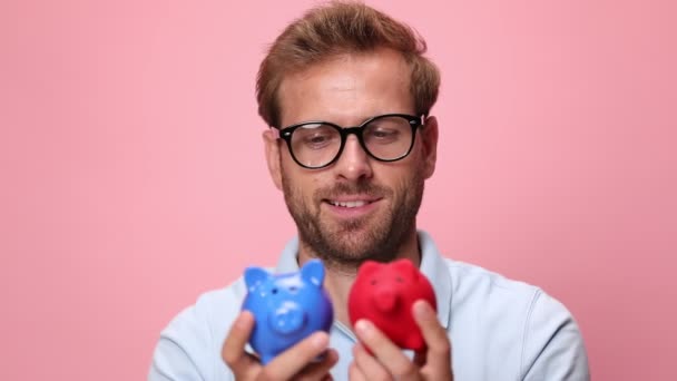 Homem Casual Jovem Inseguro Camisa Pólo Azul Segurando Porquinhos Bancos — Vídeo de Stock