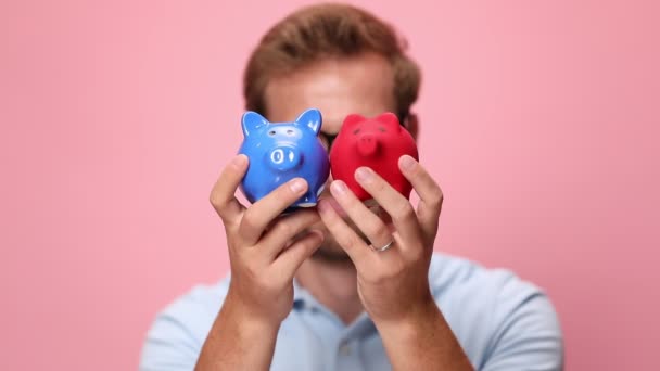 Feliz Jovem Casual Homem Azul Polo Camisa Segurando Porquinho Bancos — Vídeo de Stock