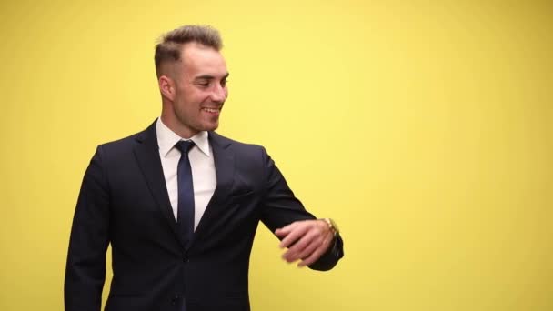 Sexy Geschäftsmann Zeigt Auf Eine Seite Und Lächelt Auf Gelbem — Stockvideo