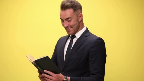 Genç Işadamı Kitabını Okuyor Konuda Çok Heyecanlı Sarı Arka Planı — Stok video