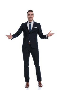 Pozitif iş adamı beyaz stüdyo arka planında dururken gülümsüyor.