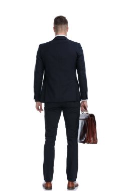 Çantayı tutan ve beyaz stüdyo arka planında duran işadamlarının arka görünüşü