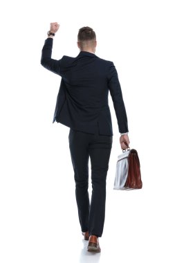 İş adamlarının evrak çantasını tutarken ve kutlama yaparken beyaz stüdyo geçmişine adım atarken.