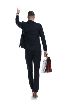 Elinde evrak çantası olan işadamlarının arka plan görüntüsü ve beyaz stüdyo arka planında yürümeleri.