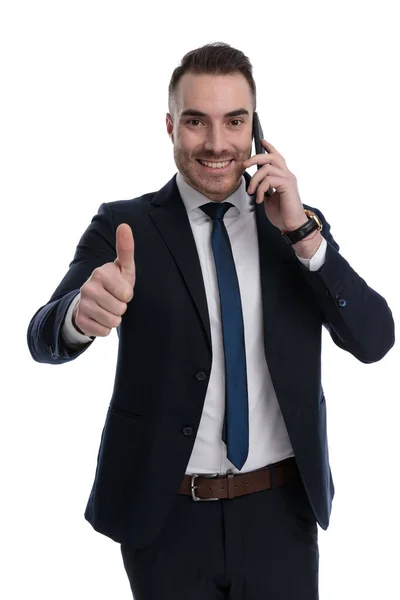 Smiling Businessman Giving Thumbs Talking Phone While Standing White Studio — Fotografia de Stock