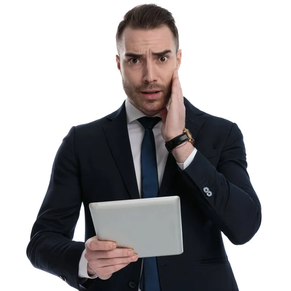 Bezorgde Zakenman Holding Tablet Fronsen Terwijl Staan Witte Studio Achtergrond — Stockfoto