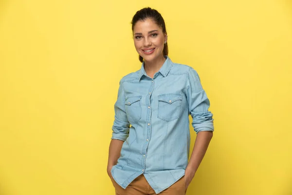 Sorrindo Mulher Casual Segurando Mãos Seus Bolsos Enquanto Estava Fundo — Fotografia de Stock