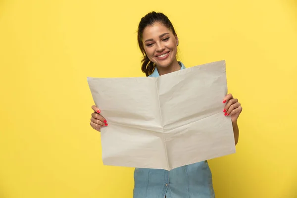 Positive Casual Woman Smiling Reading Newspaper While Standing Yellow Studio — Stock Photo, Image