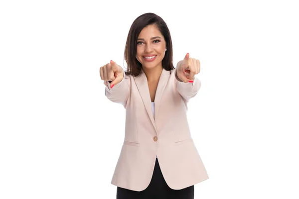 站在白工作室的背景上 一位积极的女商人双手指指点点 面带微笑 — 图库照片