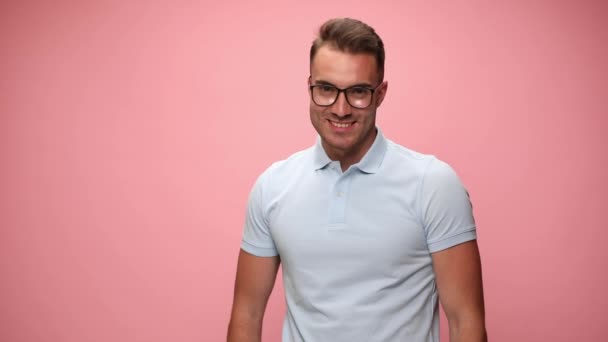 Guapo Joven Casual Hombre Sonriendo Fijando Sus Gafas Golpeando Una — Vídeos de Stock