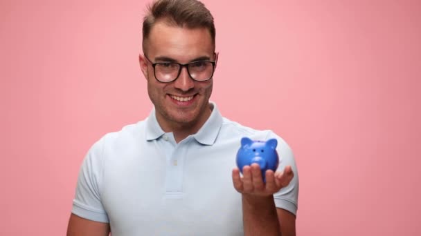 Jovem Casual Homem Segurando Porquinho Banco Dando Polegar Para Cima — Vídeo de Stock