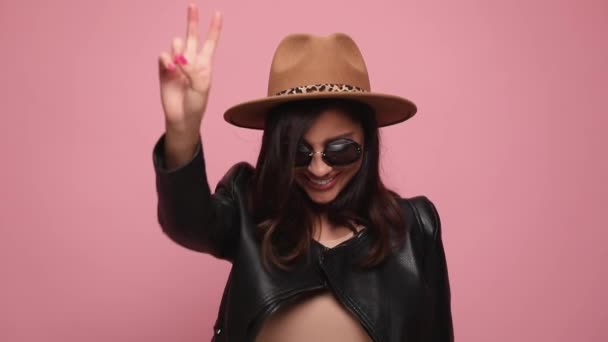 Deri Ceketli Şapkalı Güneş Gözlüklü Seksi Bir Kadın Barış Jesti — Stok video