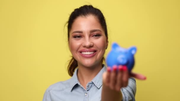 Niña Camisa Mezclilla Azul Sonriendo Poniendo Moneda Alcancía Ahorrando Dinero — Vídeo de stock
