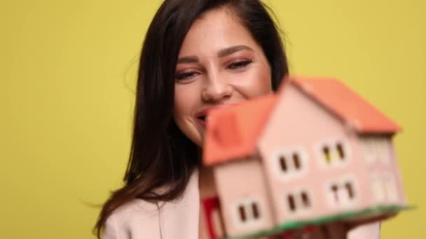 Atrakcyjna Bizneswoman Trzymająca Model Domu Celująca Kamerę — Wideo stockowe