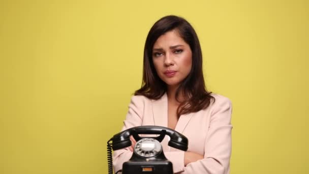 魅力的なビジネスマンの女性は 古い電話を見て 答えを躊躇し 彼女の顔に触れ 怖がらせ 腕を交差させ 何をすべきか見当もつかない — ストック動画