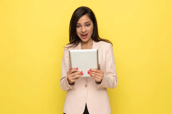 Excited Young Woman Wearing Pink Suit Holding Tab Reading News — Stock Photo, Image