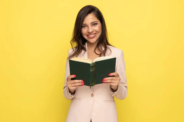 Gelukkig Brunette Zakenvrouw Roze Pak Lezen Boek Glimlachen Gele Achtergrond — Stockfoto