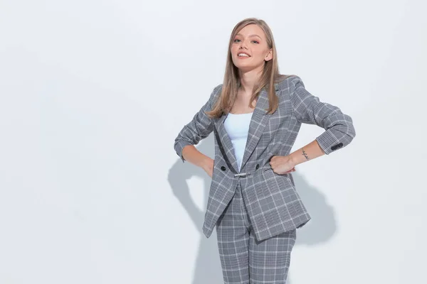 白いスタジオの背景に立っている間にスーツを着て 腰に手で笑顔積極的なファッションビジネス女性 — ストック写真