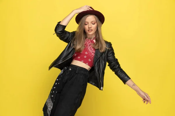 Glückliches Modelmodel Das Seinen Hut Fixiert Und Auf Gelbem Studiohintergrund — Stockfoto