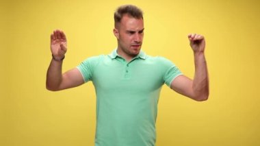 Konuşan, tartışan, kavga eden iki eli taklit eden, sarı arka planda patlayana kadar dövüşen seksi, sıradan bir adam.