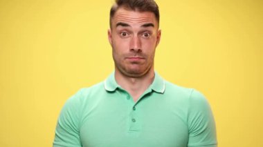 Gelişigüzel yakışıklı bir adam aldığı haberden dolayı şaşırır, kafasına işaret eder ve sarı arka planda çılgın bir işaret gösterir.