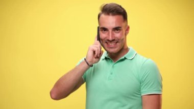 Sıradan bir adam telefonda konuşuyor, şok oluyor, yüzüne tokat atıyor, sarı arka planda yanaklarını şişiriyor.